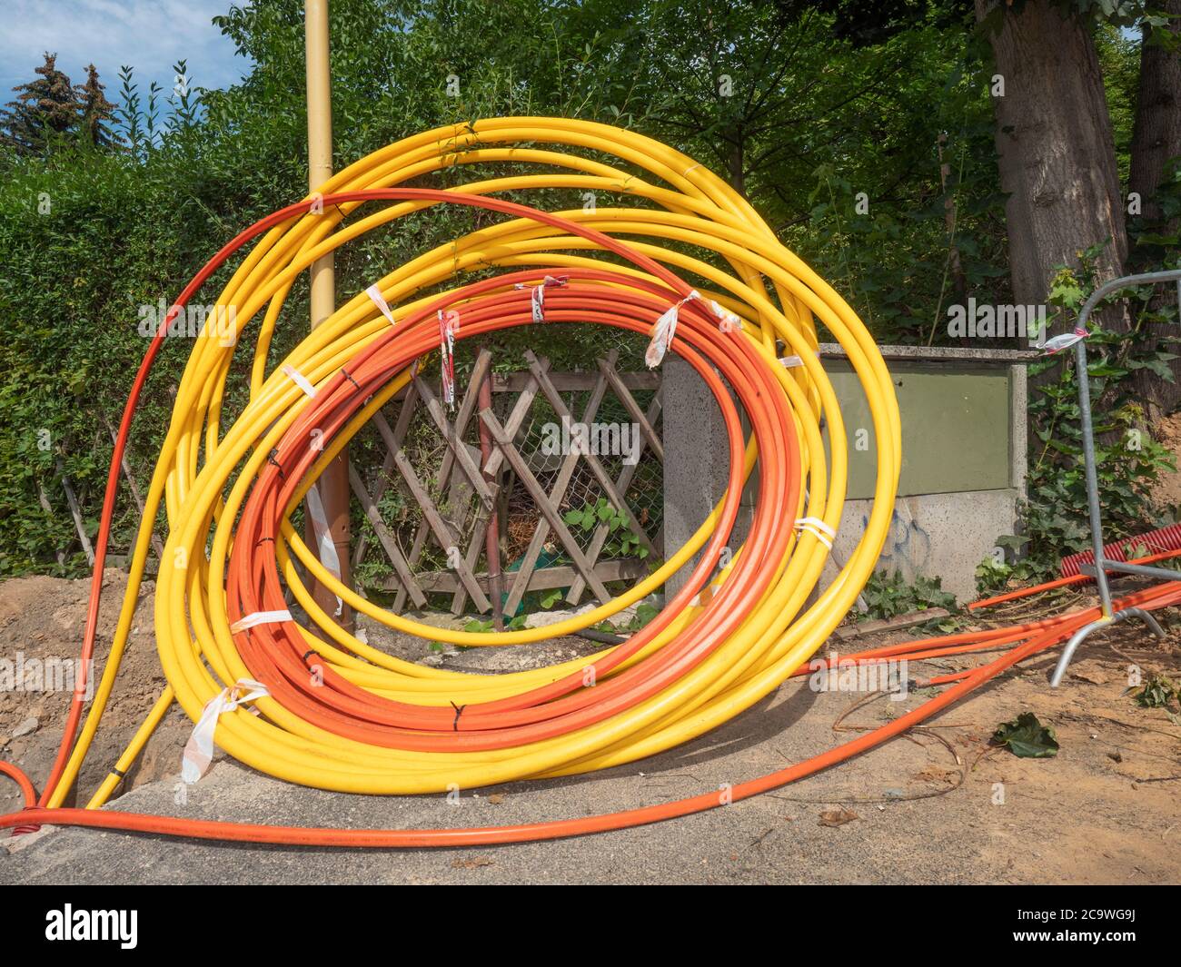 Coils of plastic casings, data cable put in underground trench. Fiber