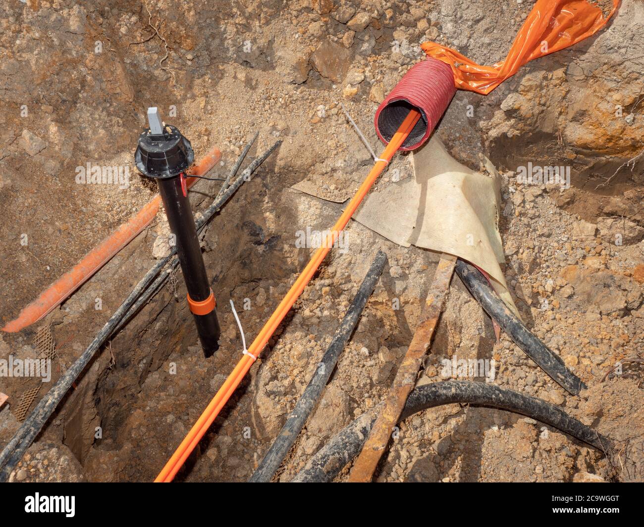 Safety tube with optic fiber cables. Bulding site with trench for