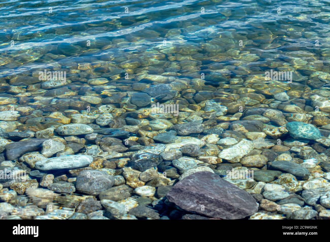 Close view of rocky riverbed under clear freshwater Stock Photo