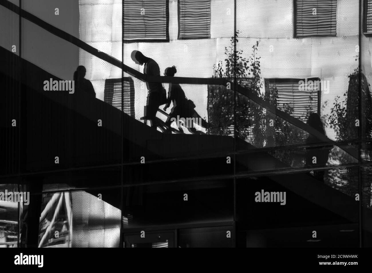 Reflection of people walking up and down some stairs in the city Stock Photo