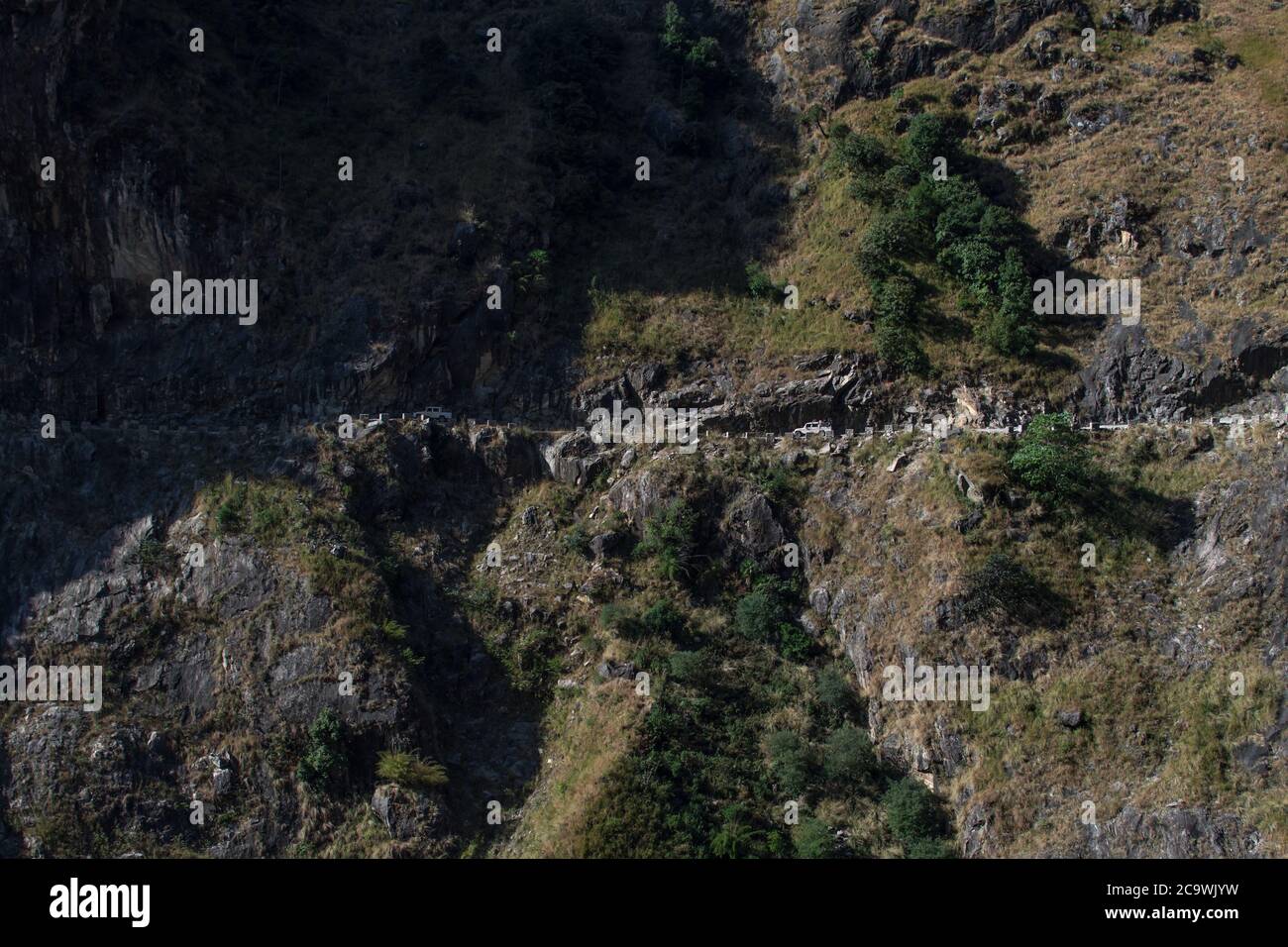 Two cars driving close to a steep edge on the road to Manang, Annapurna circuit, Nepal Stock Photo
