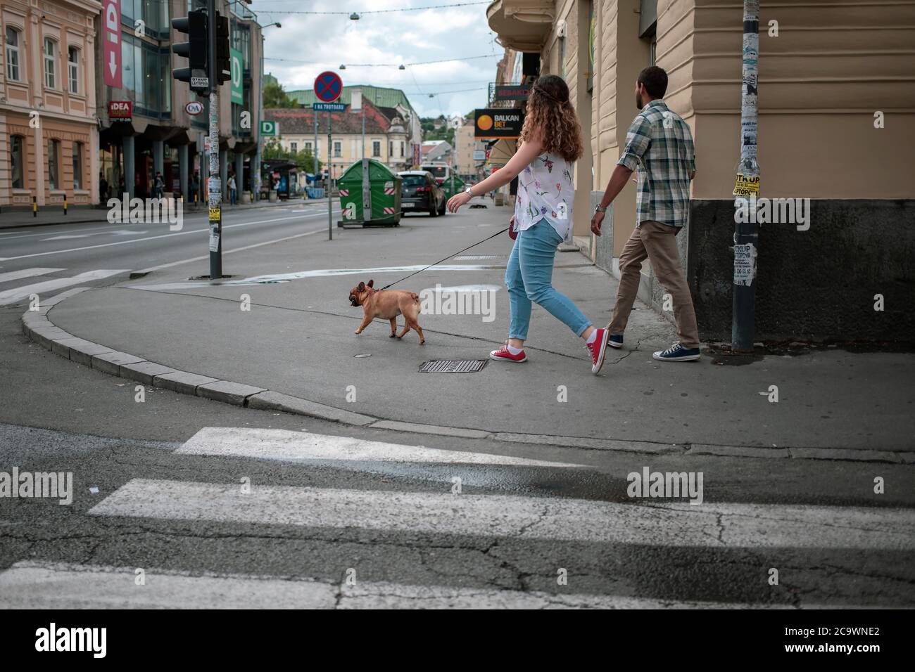 Belgrade, Serbia, Jul 19, 2020: Couple walking dog down the street in Zemun Stock Photo