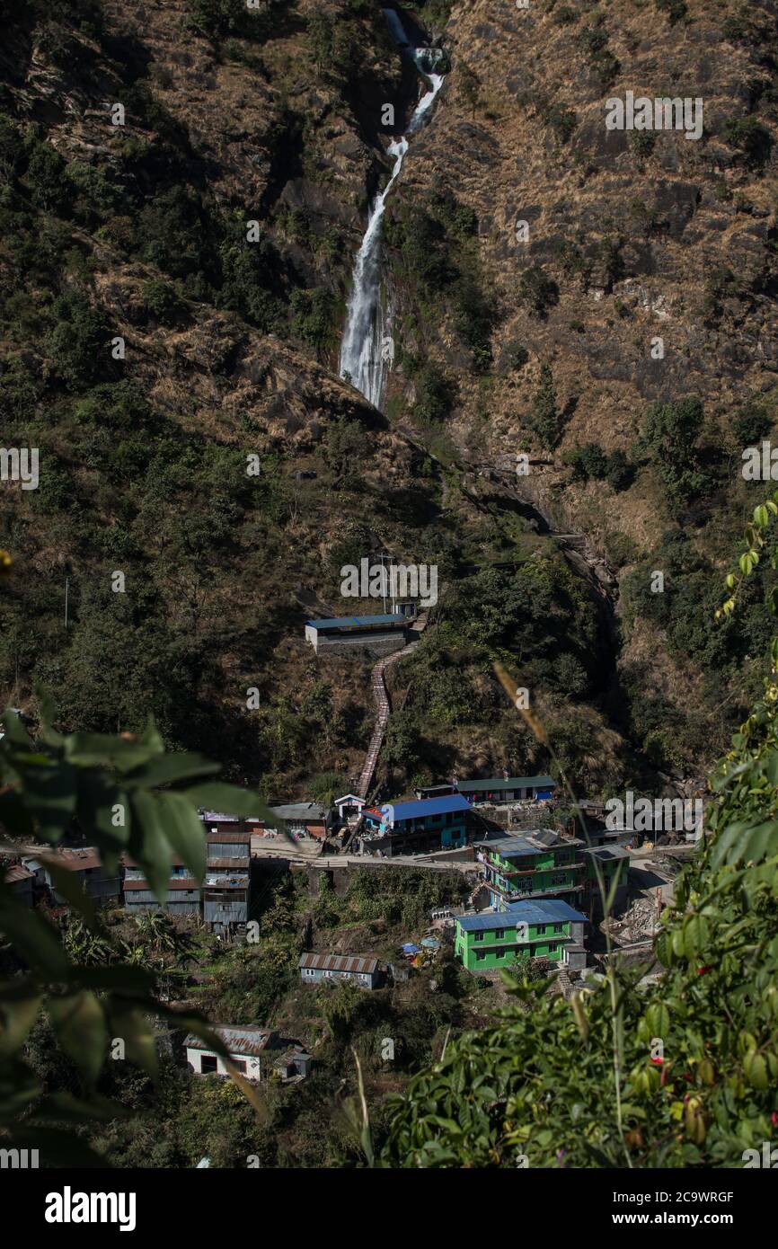 Waterfall flowing above a nepalese mountain village at Annapurna circuit Stock Photo