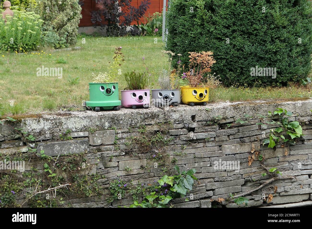 Four vacuum cleaners used as planters Stock Photo