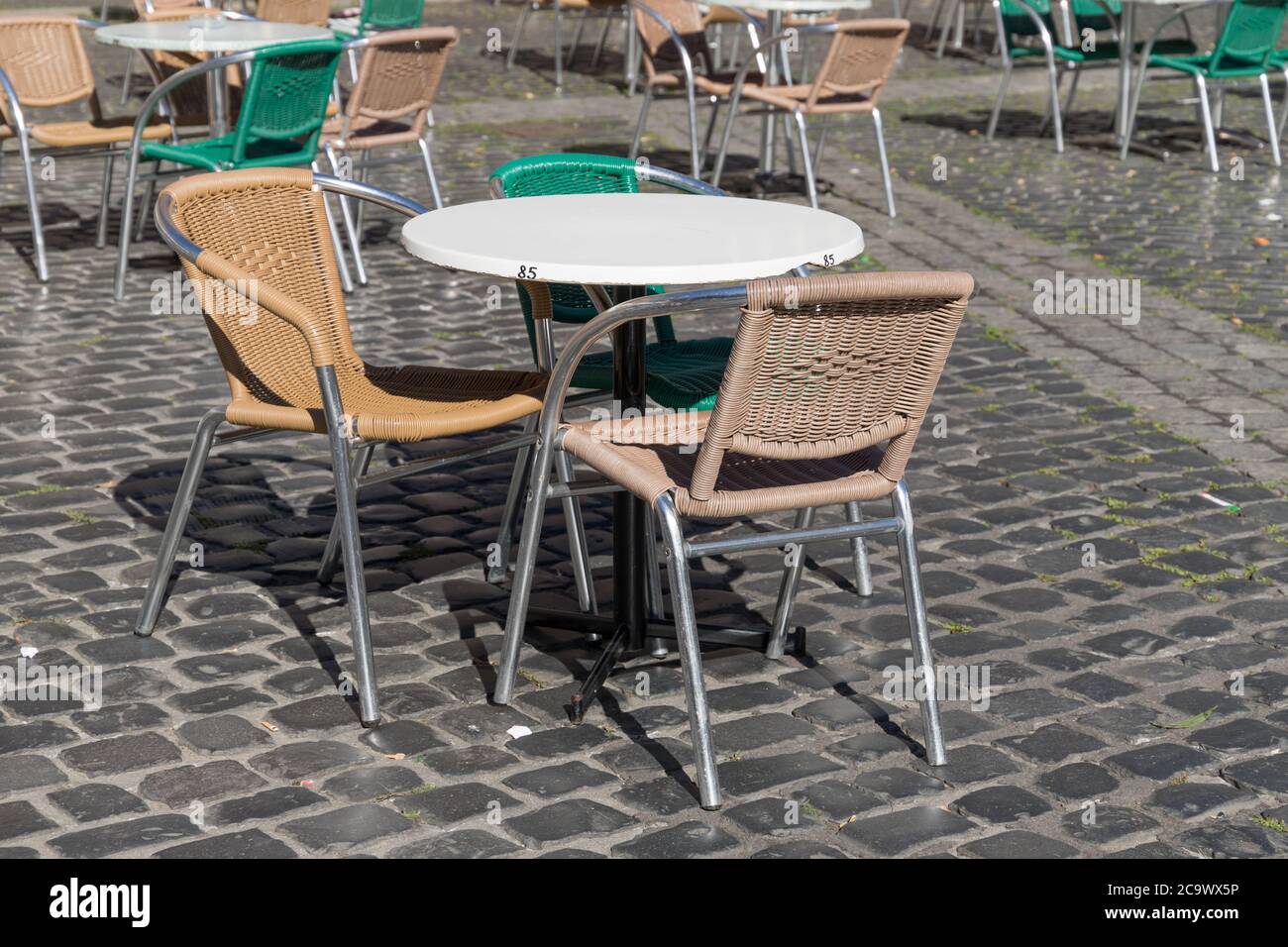 empty tables and chairs outside of a restaurant in pandemic times Stock Photo