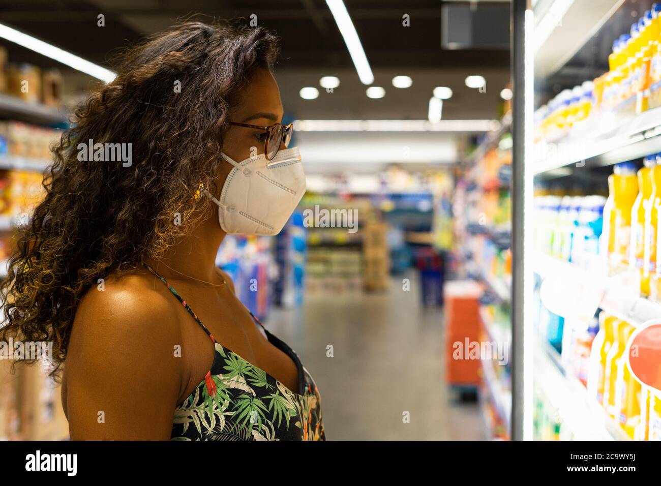 Brazilian young woman shopping in the supermarket with mask. New normality concept. Stock Photo