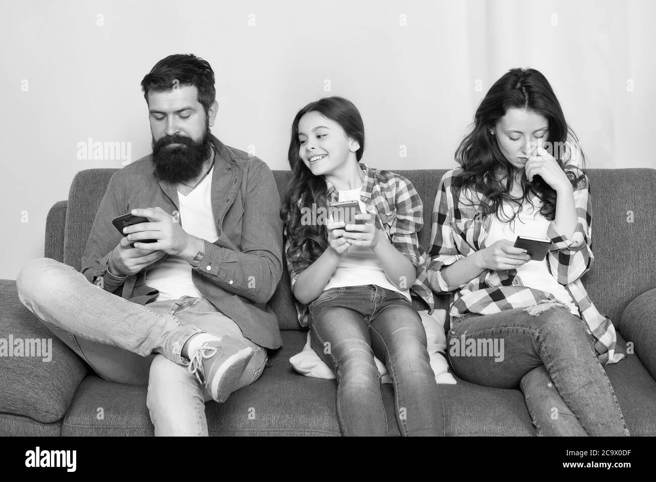 Mom dad and daughter relaxing on couch. Family spend weekend online