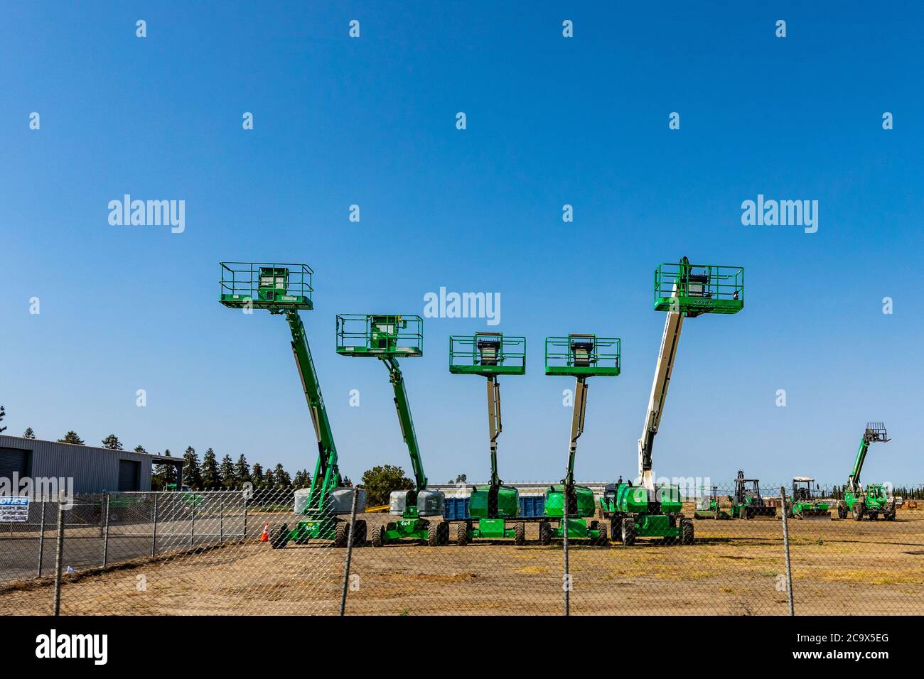 A bevy of man lift machines at a rental facility in Atwater in the Central Valley of California USA Stock Photo