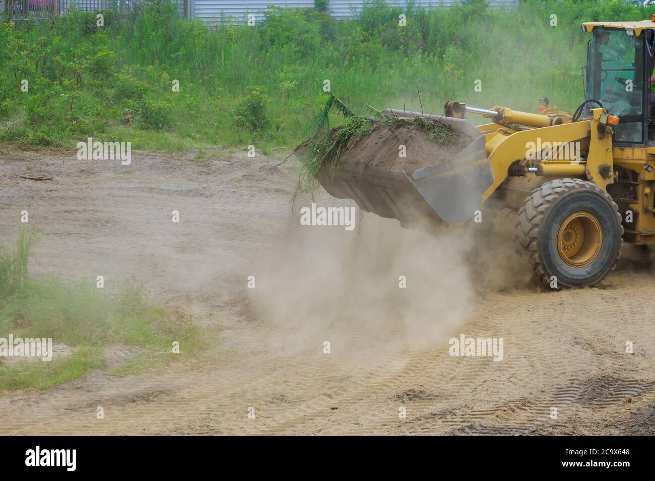 Bulldozer moving, leveling ground at construction site in ground using shovels Stock Photo