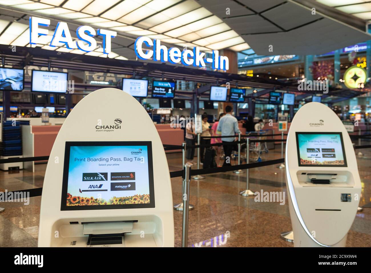 Passengers at Singapore Changi airport terminal 4 departures counter self  check in area Stock Photo - Alamy