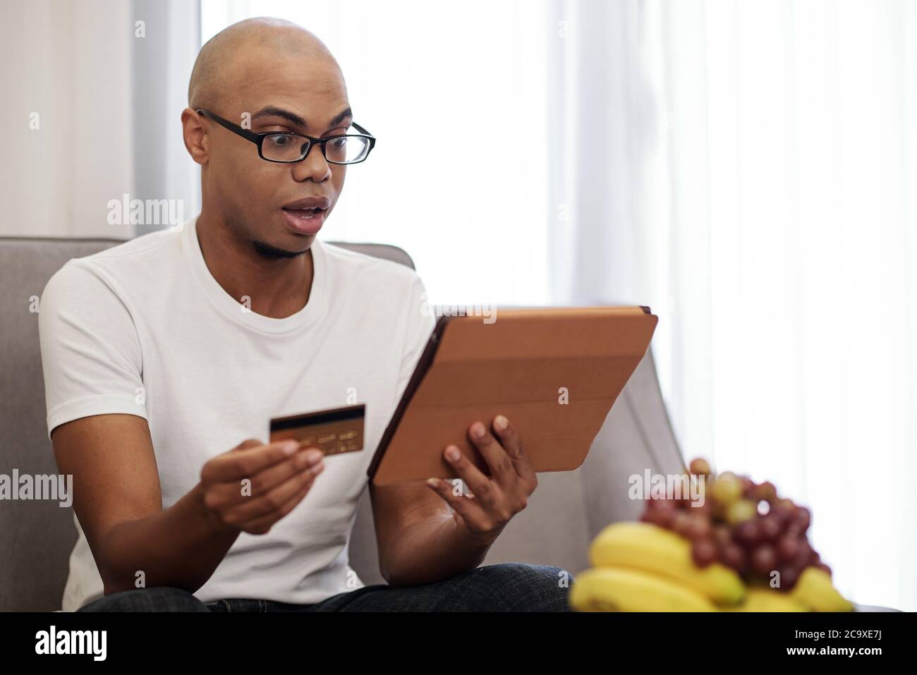 Shocked black man sitting in hi-res stock photography and images - Alamy