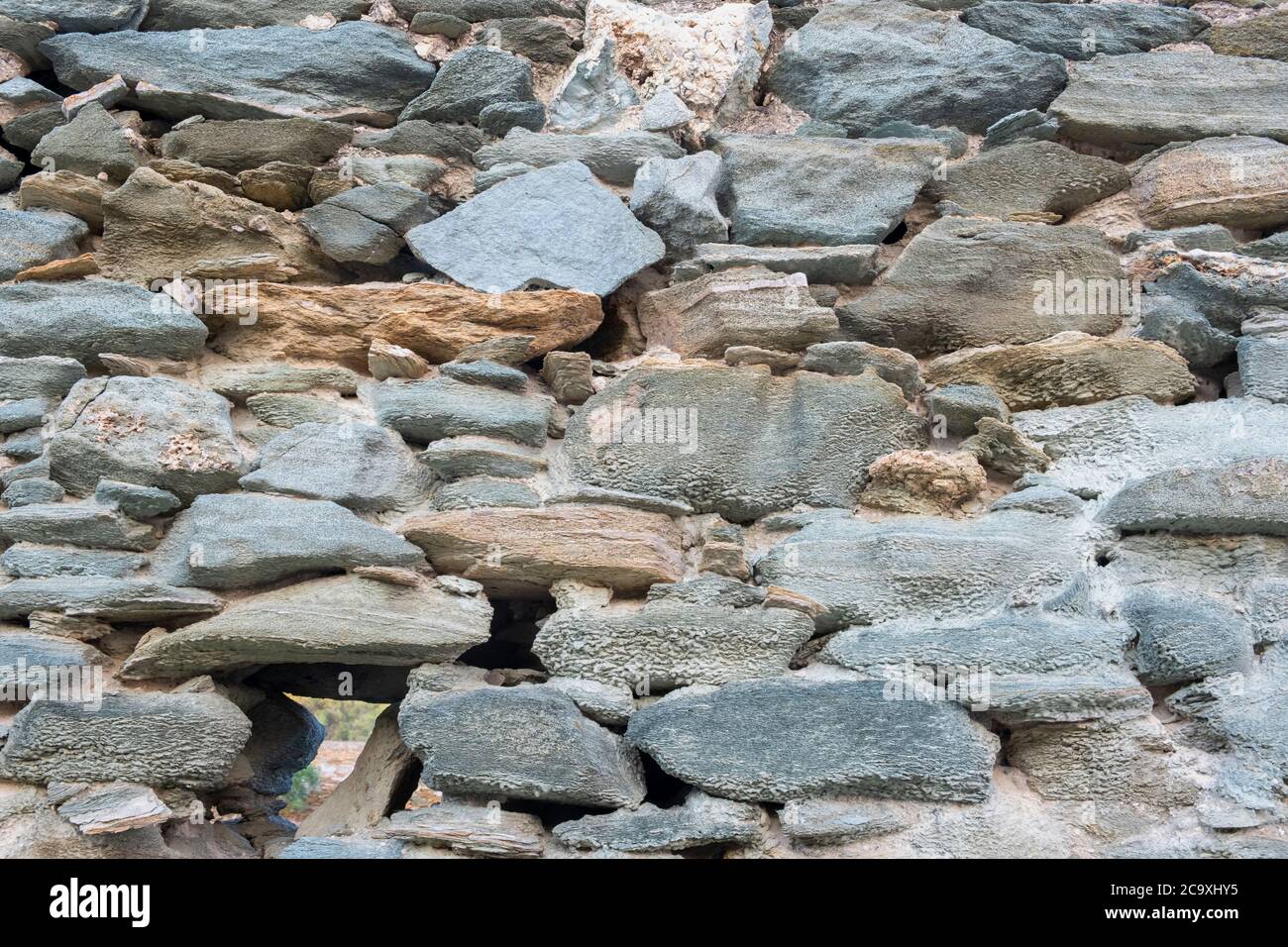 Stone and rock wall background. Vintage gray green color stone wall background and texture, Traditional greek island architecture and construction Stock Photo