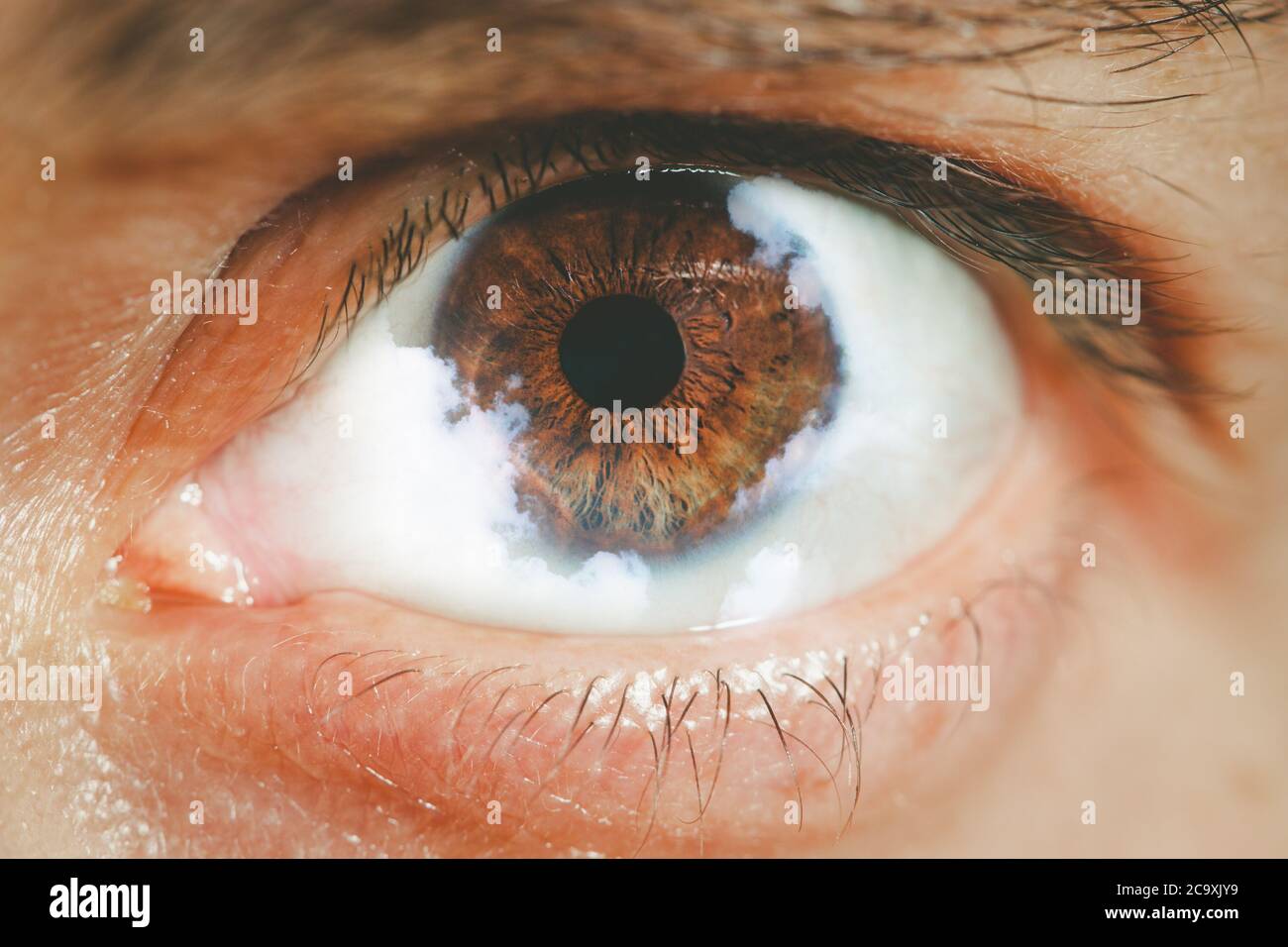 Extreme closeup of human eye with clouds cloudy vision concept Stock