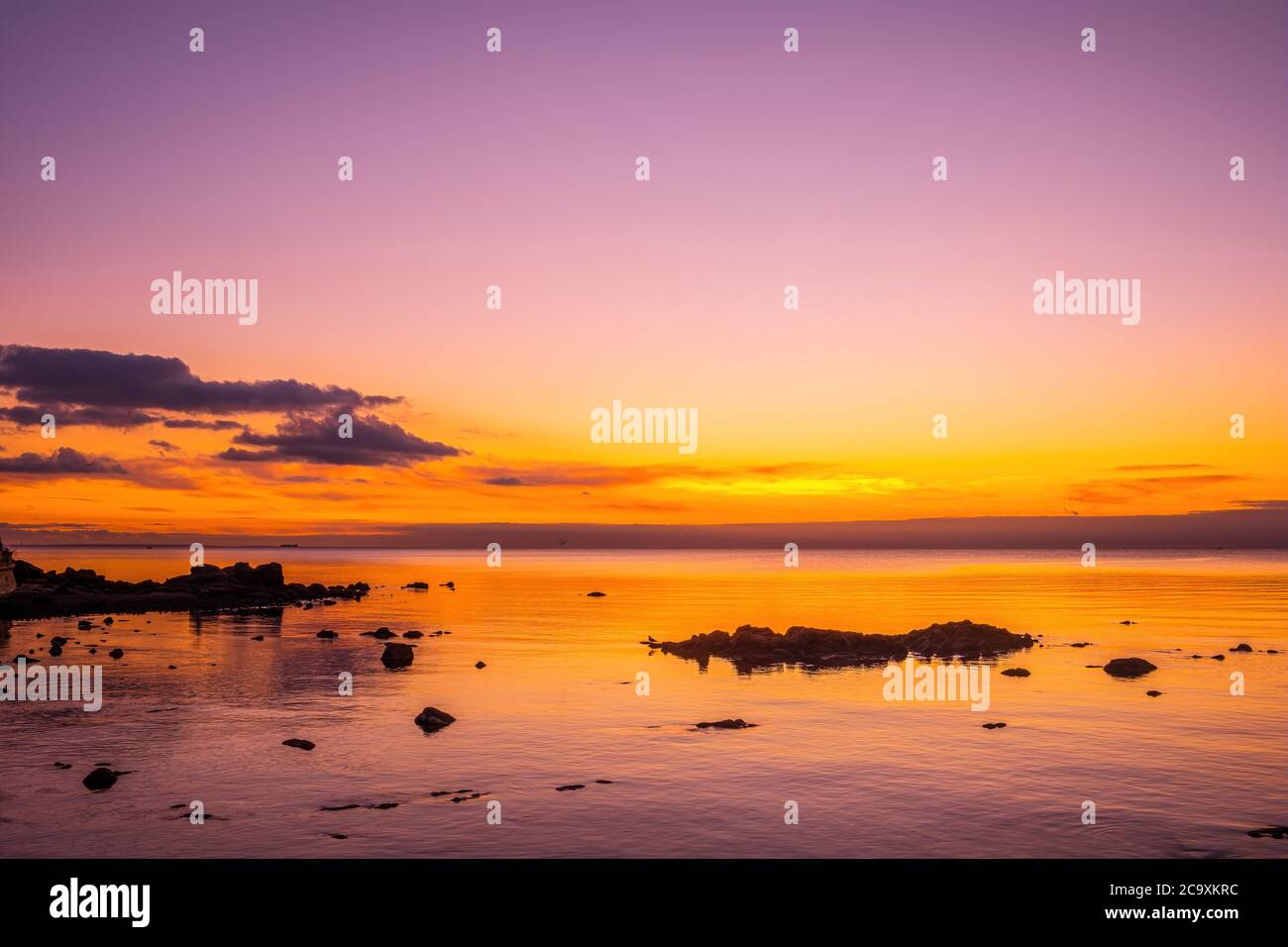 Amazing view of glowing golden sunset over ocean and coastline rocks ...