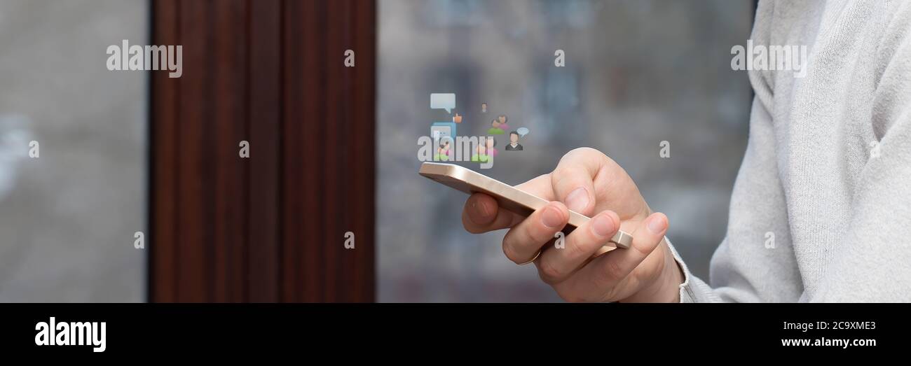 a mobile phone in the hands of a man who participates in an online video conference or remote training webinar. The concept of distance relationship Stock Photo