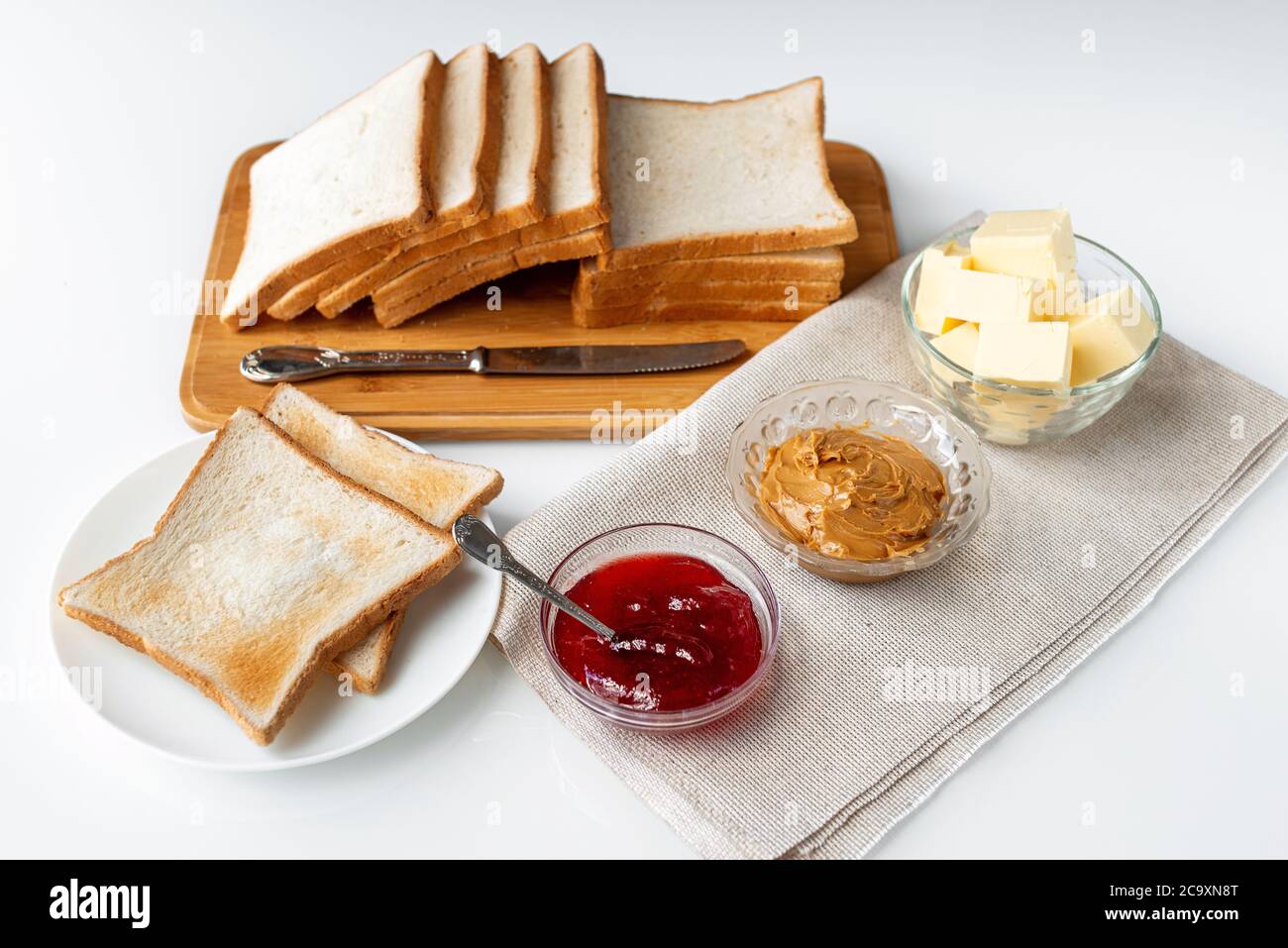 Ingredients For A Delicious Breakfast Toasted Bread Butter Peanut Butter And Homemade Raspberry Jam On A Table Stock Photo Alamy