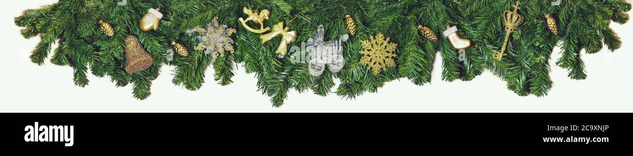 Christmas decoration garland of fir branches, gold toys, snowfalls and bells.wide arched. Christmas border, isolated on a white background, made up of Stock Photo