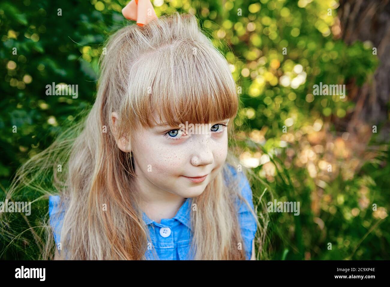 charming little girl with blue eyes and long Golden hair is smiling. Happy funny child Stock Photo