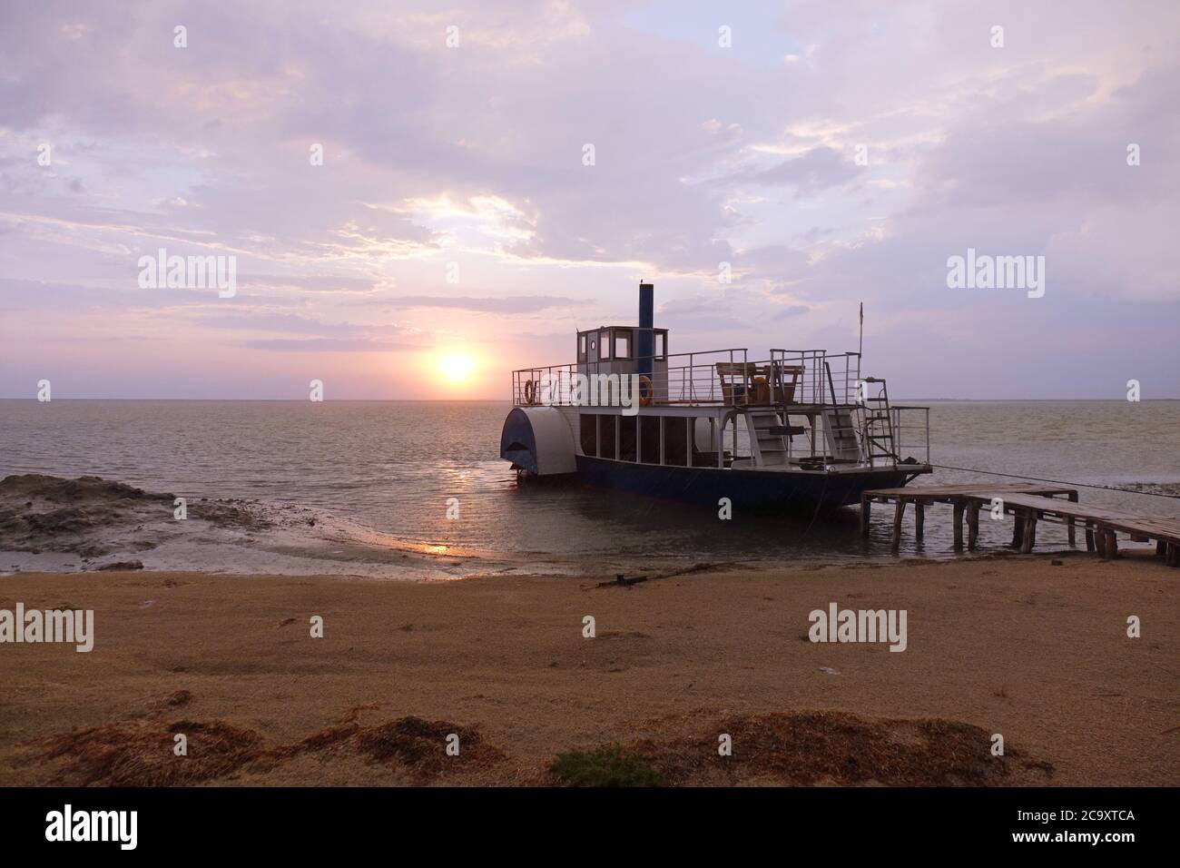 paddle wheel ship on the pier at sunset Stock Photo