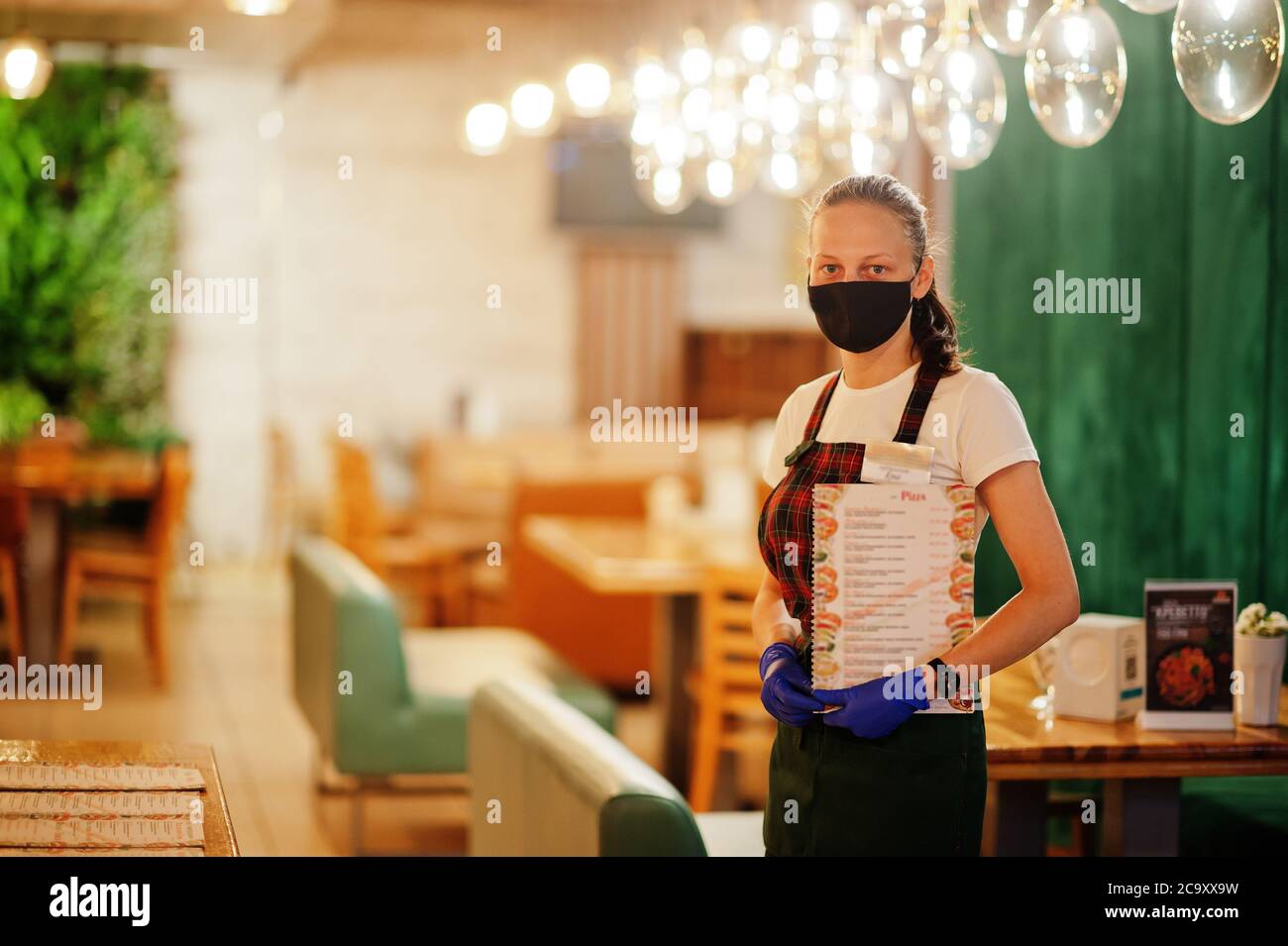 Waiter hold menu in protective mask in the restaurant Stock Photo - Alamy