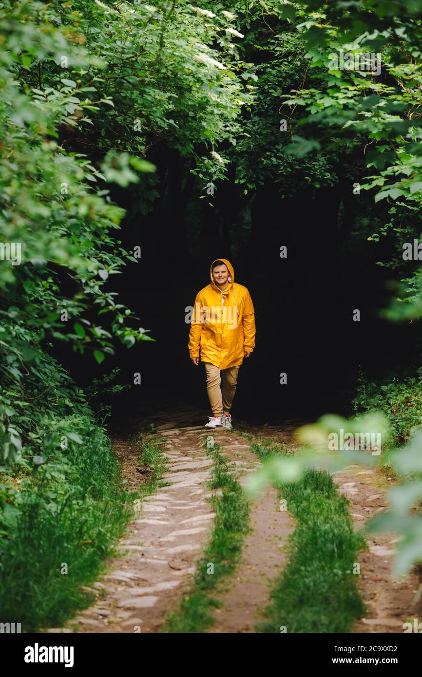 traveler man in yellow raincoat hiking by rainy forest Stock Photo - Alamy