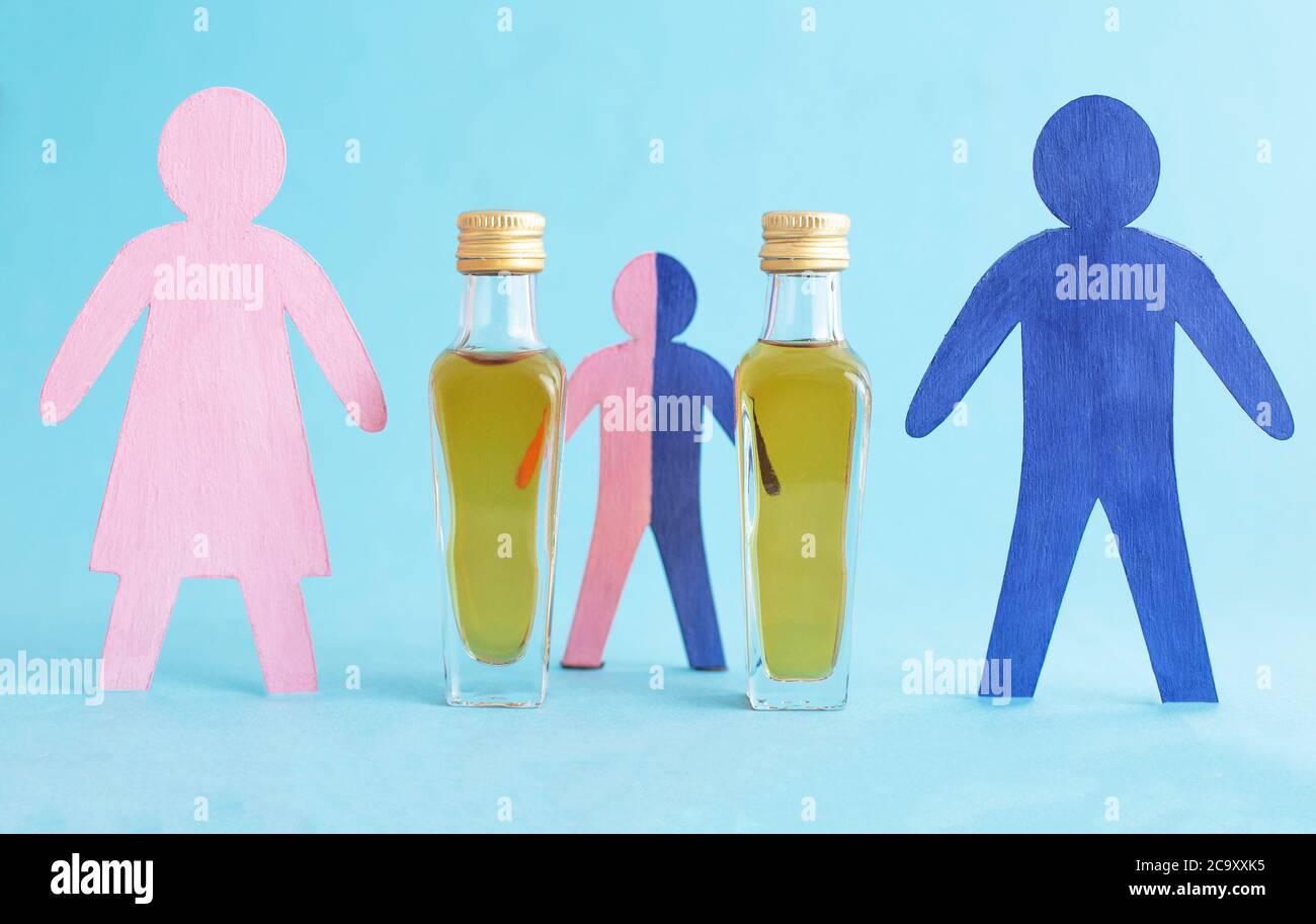 Wooden figurines in the form of people and bottles with alcohol on a blue background. Family alcoholism concept in family, alcoholism treatment, drink Stock Photo