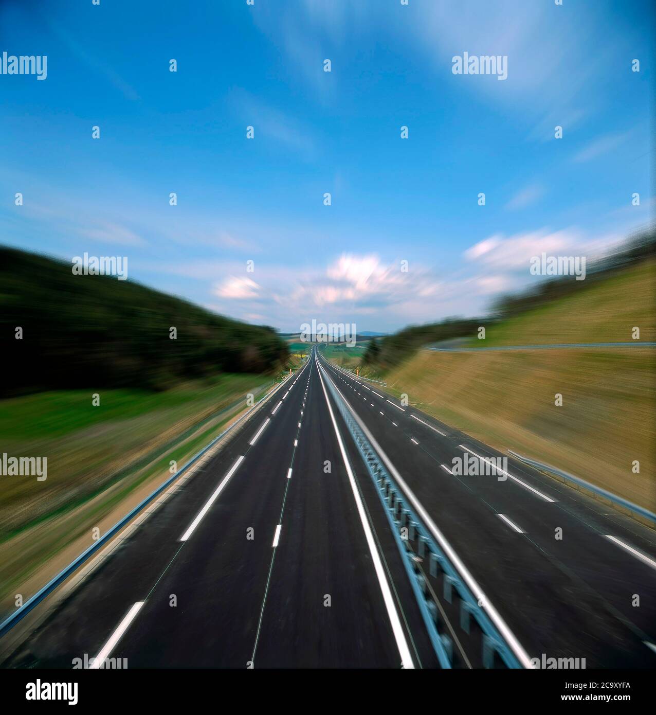 Expansive highway stretching into the horizon under a bright blue sky ...