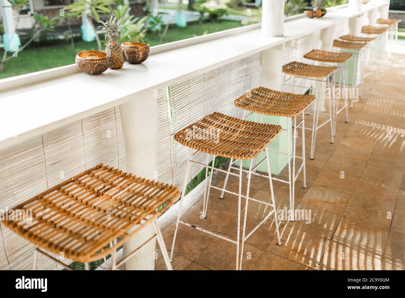 Wicker rattan chairs on bar counter. Trendy furniture design. Summer cafe terrace. Stock Photo