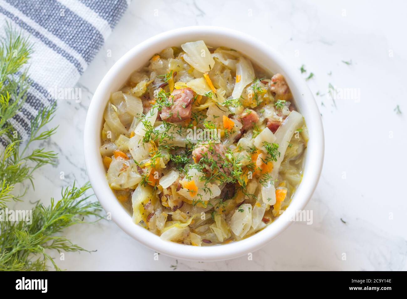 Stewed young cabbage with dill and sausage Stock Photo