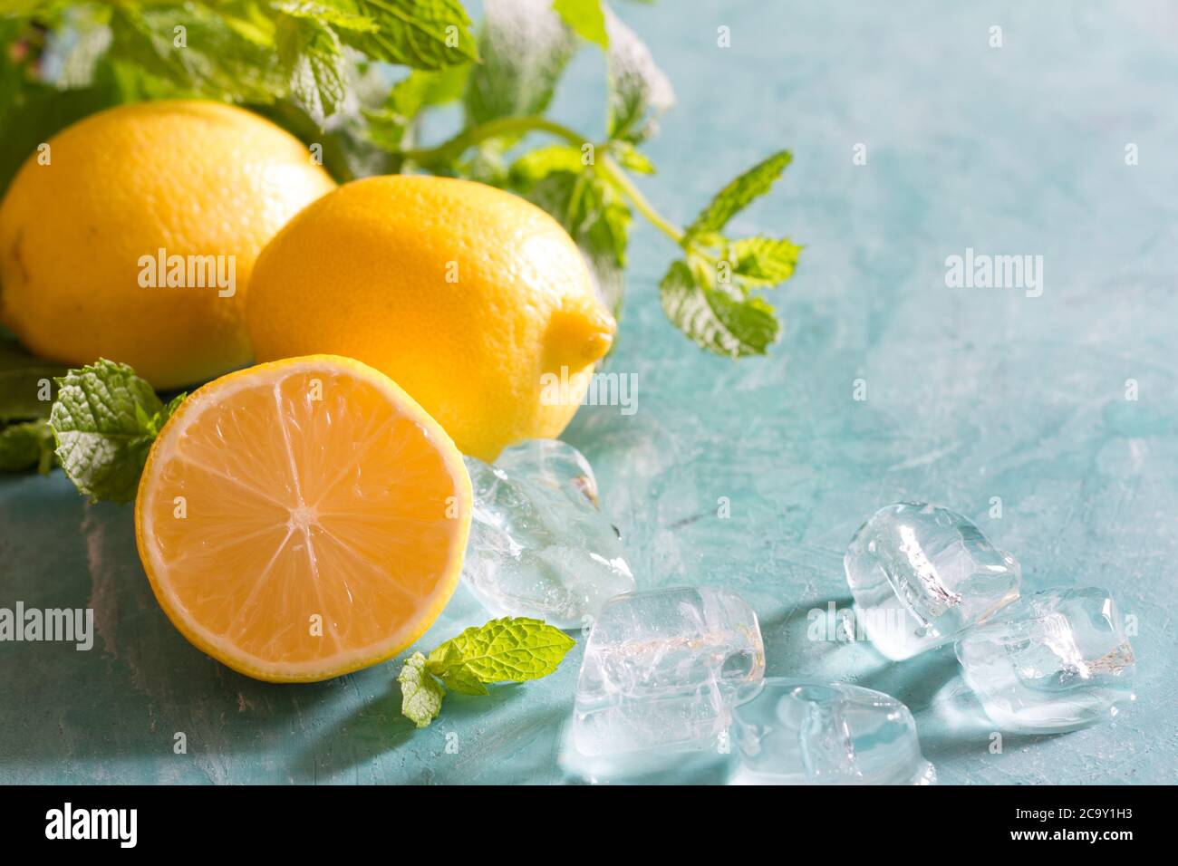 Refreshing water with lemon, mint and ice for summer heat background Stock Photo