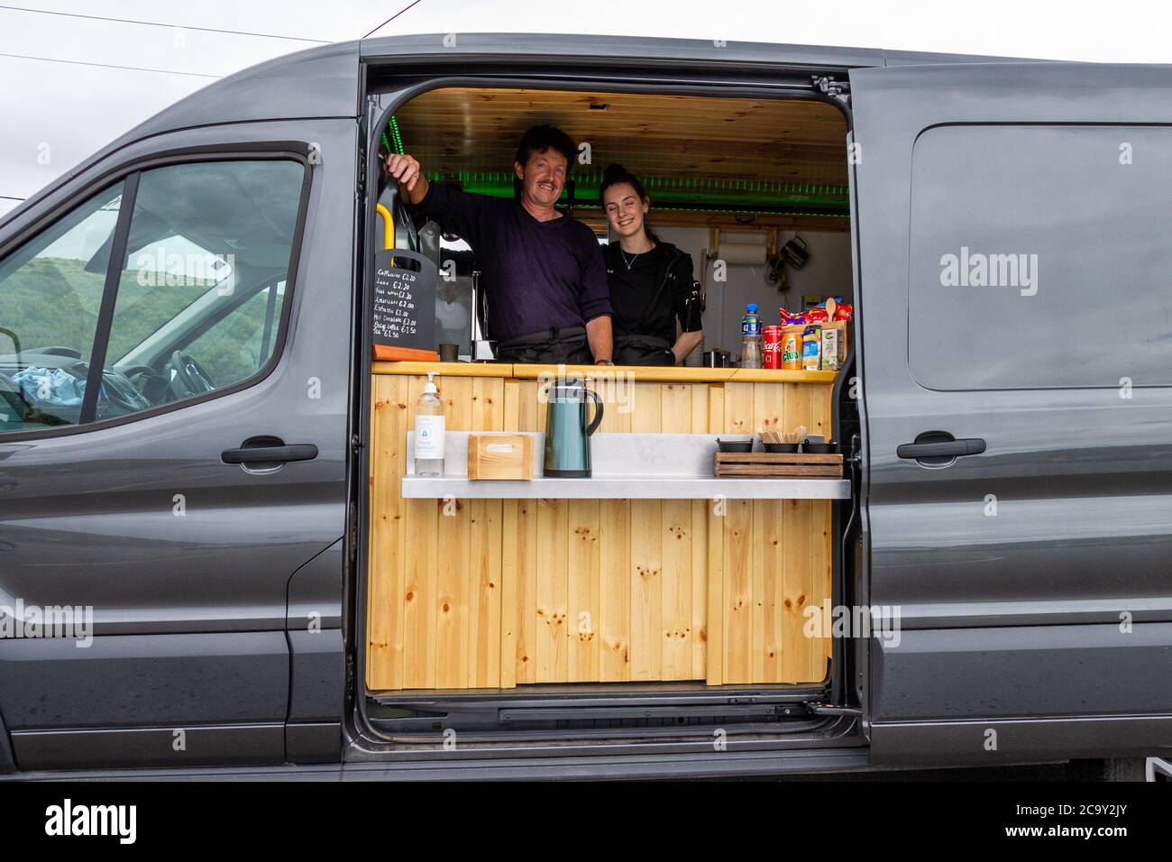 Male and female selling coffee from a mobile coffee bar Stock Photo