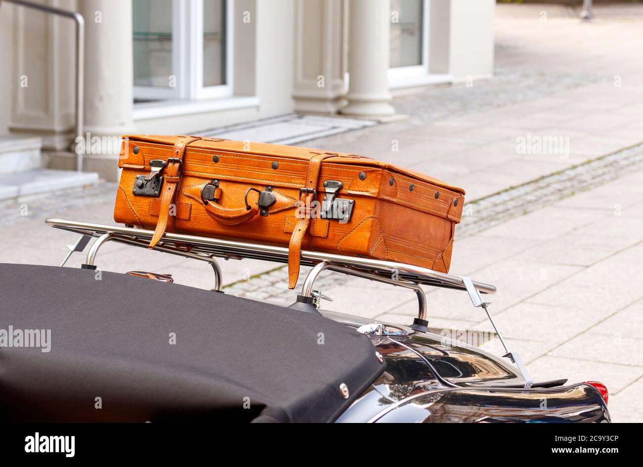 Leather suitcase on a luggage rack Stock Photo