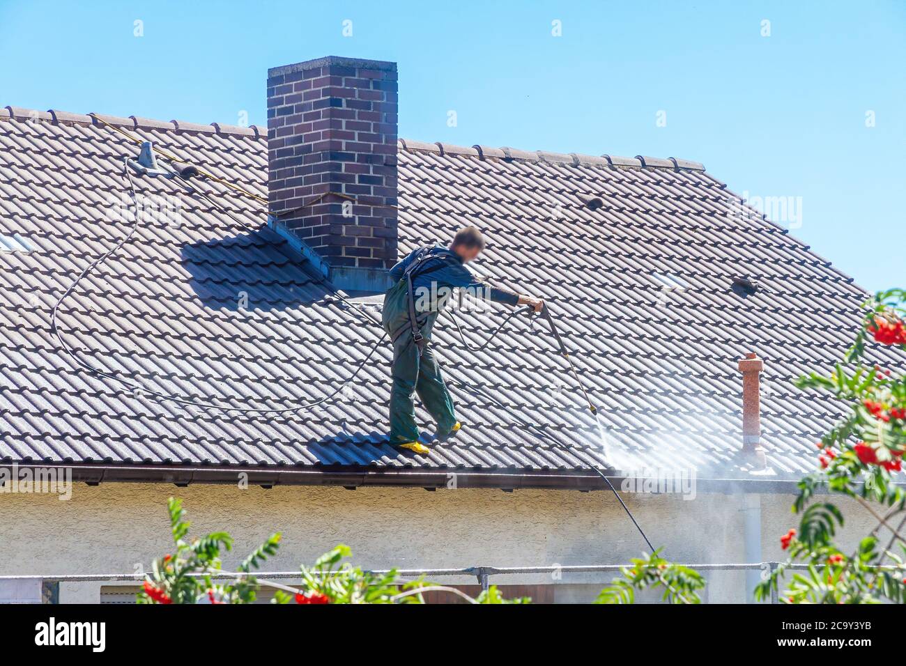 Man cleaning front and roof of a house Stock Photo
