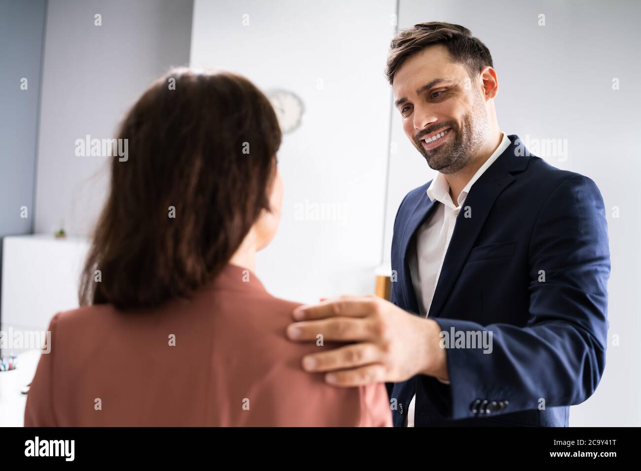 Man Putting His Hand On Woman's Shoulder Stock Photo