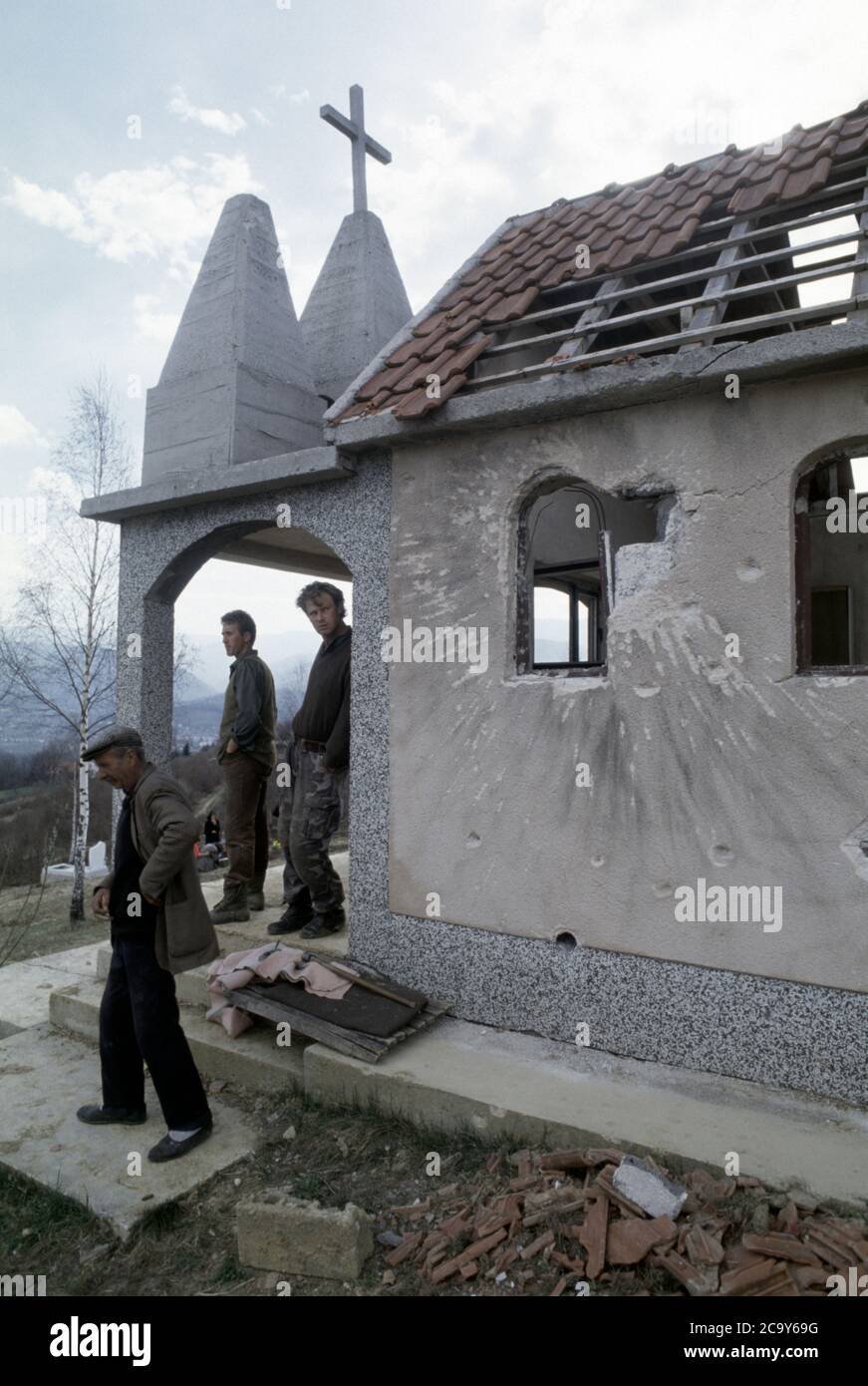 26th March 1994 During the war in Bosnia: on the front line, a small cemetery near Krčevine, just north of Vitez, Bosnian Croat soldiers stand in a small ruined chapel. Stock Photo