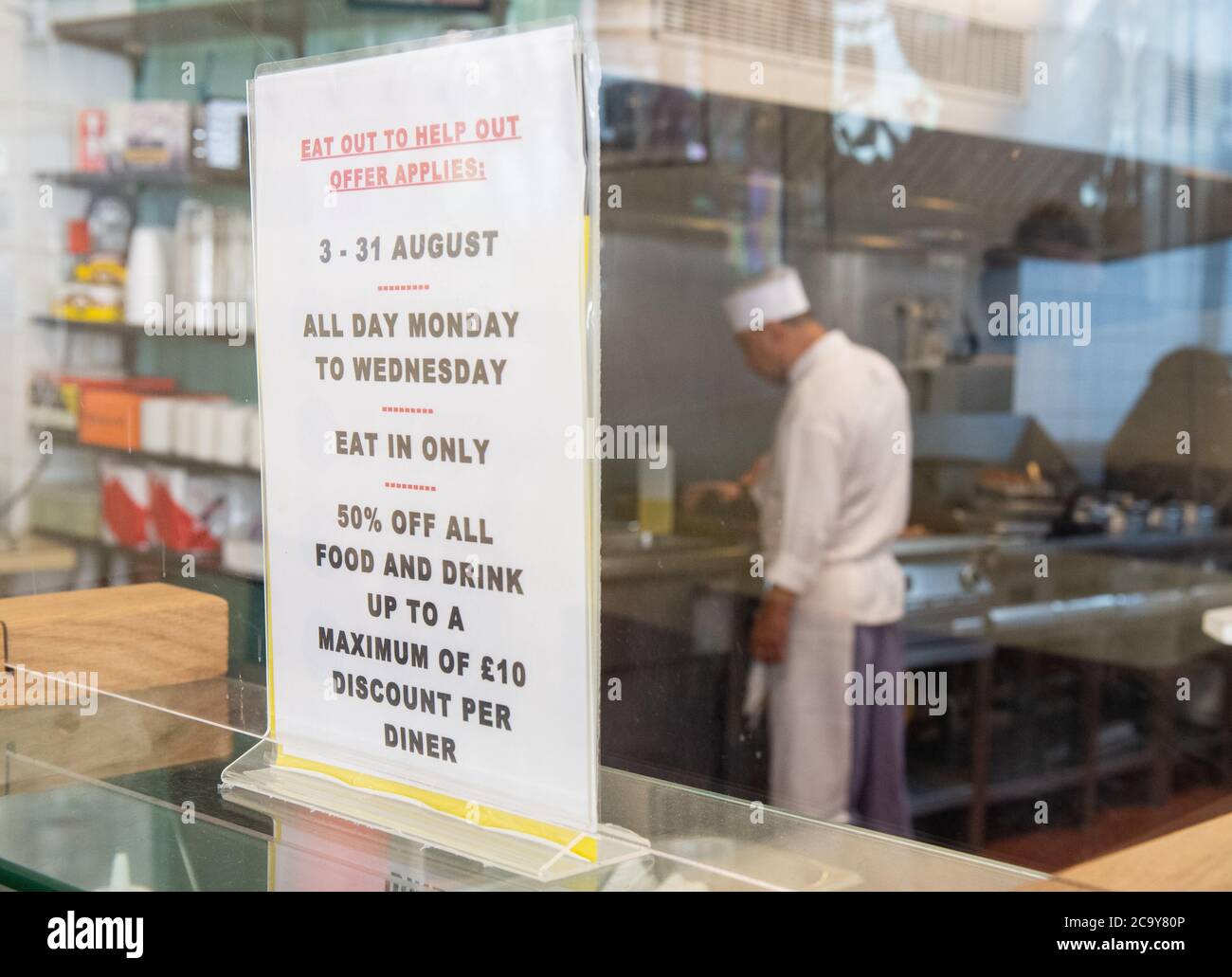 Signage for the 'Eat Out to Help Out' scheme, at the Regency Cafe, in London, one of the participating restaurants where diners will be able to enjoy half-price meals, starting on Monday as the Government kick-starts its August scheme aimed at boosting restaurant and pub trade following the lockdown. Stock Photo