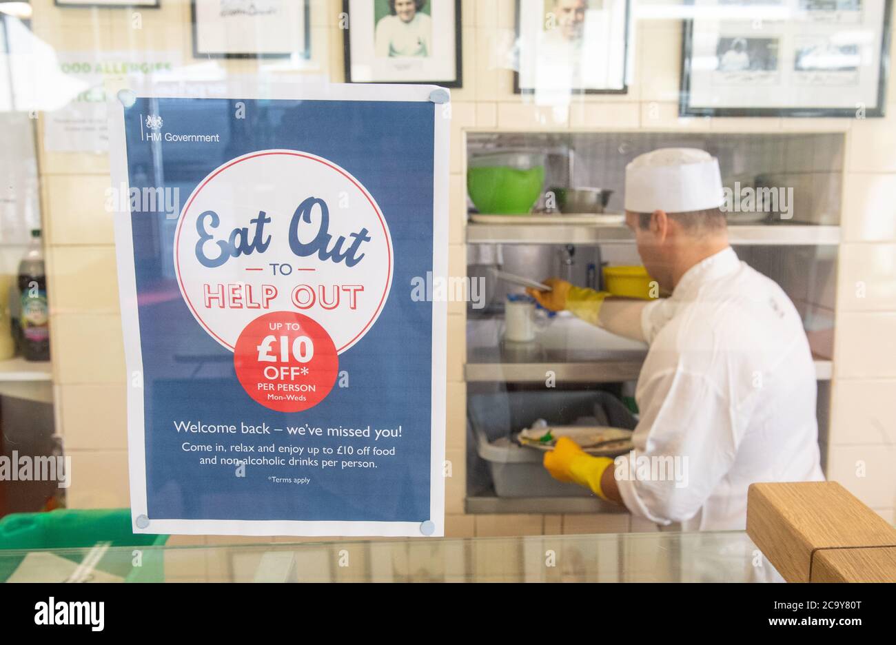 Signage for the 'Eat Out to Help Out' scheme, at the Regency Cafe, in London, one of the participating restaurants where diners will be able to enjoy half-price meals, starting on Monday as the Government kick-starts its August scheme aimed at boosting restaurant and pub trade following the lockdown. Stock Photo