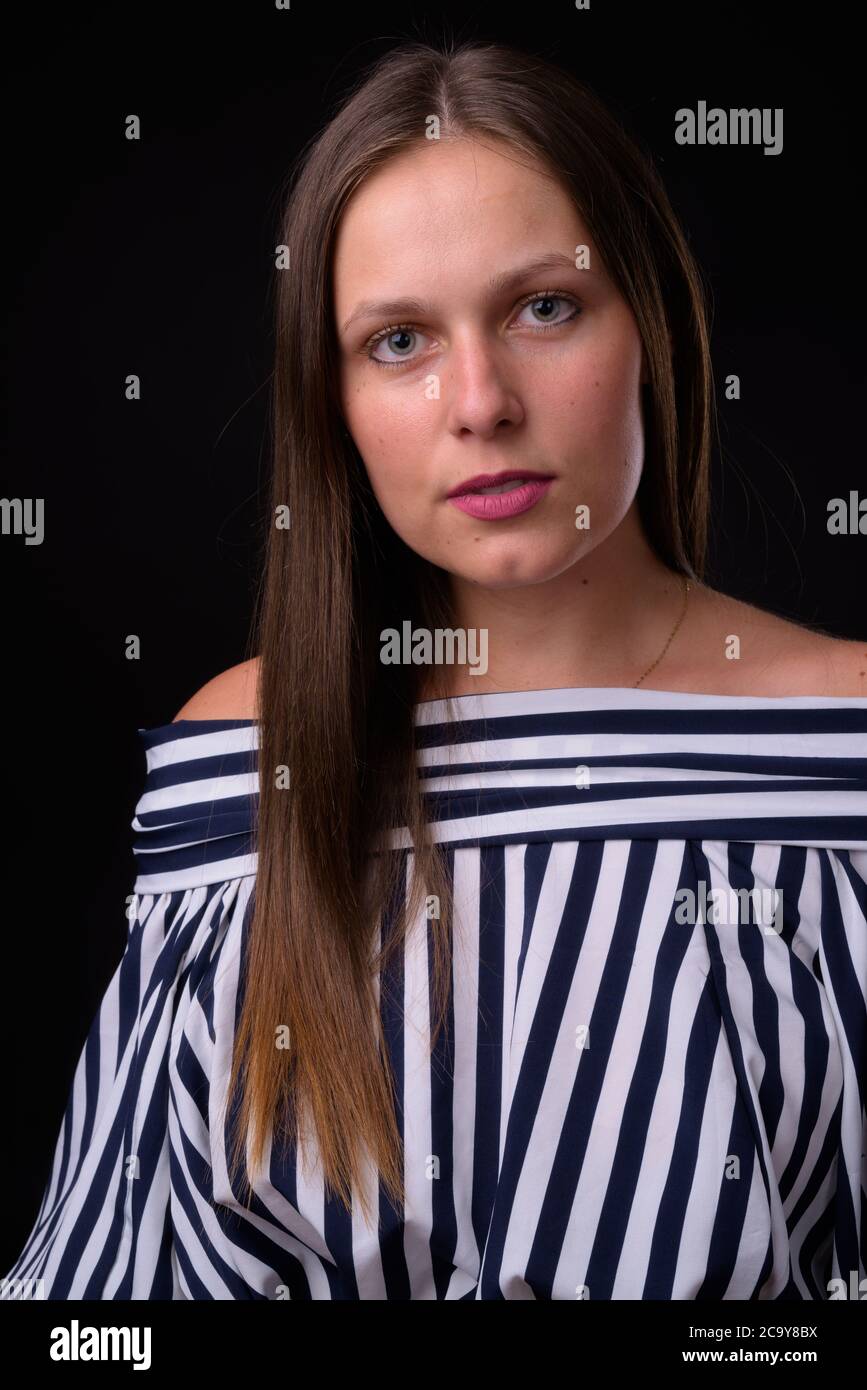 Portrait of young beautiful woman against black background Stock Photo ...