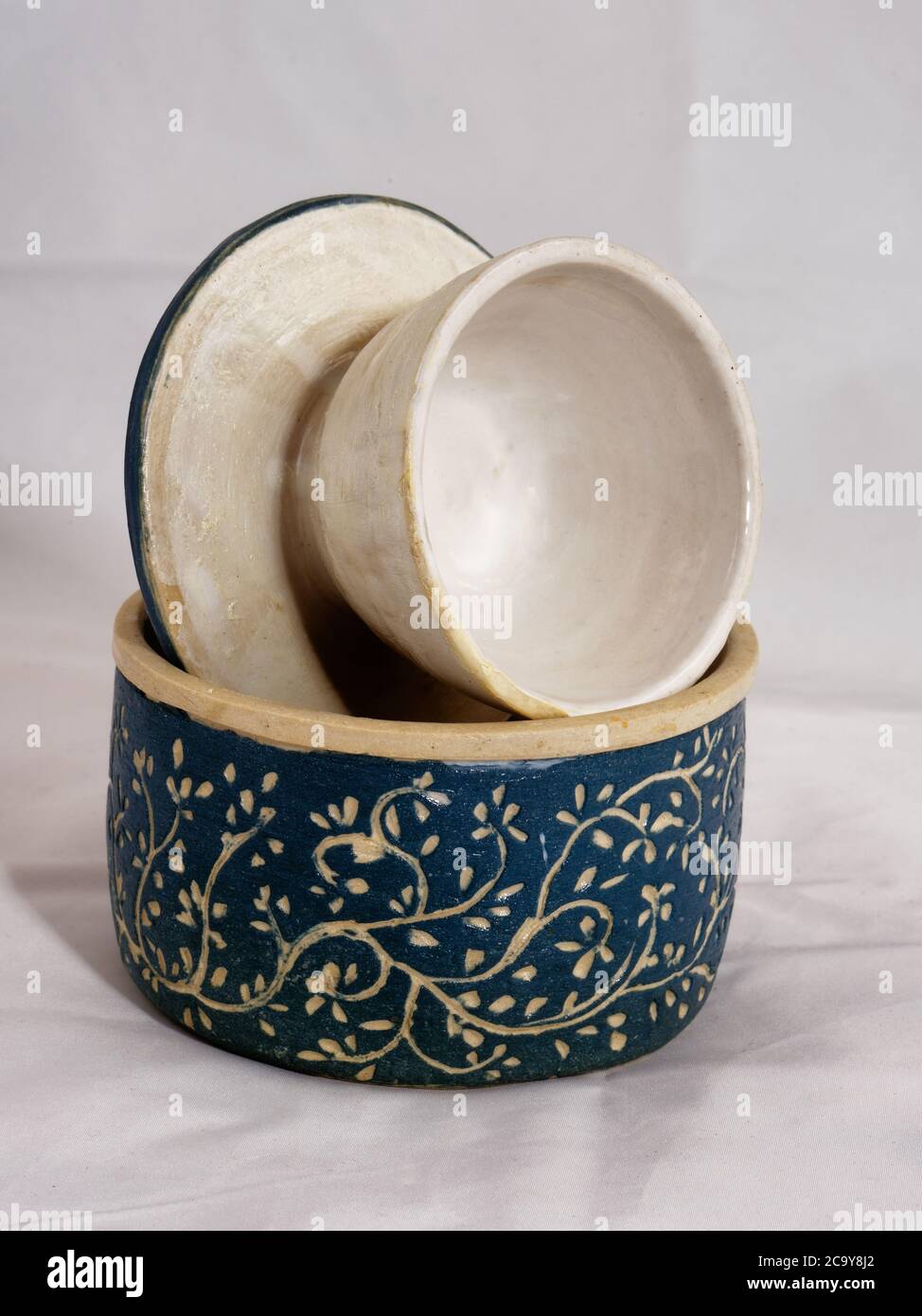 Hand made traditional ceramic butter bell pottery with blue finish and leaf pattern Stock Photo