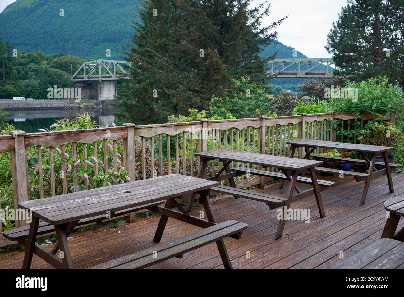 The outside seating area of the Loch Leven Hotel with a distant view of the Ballachulish Bridge Stock Photo