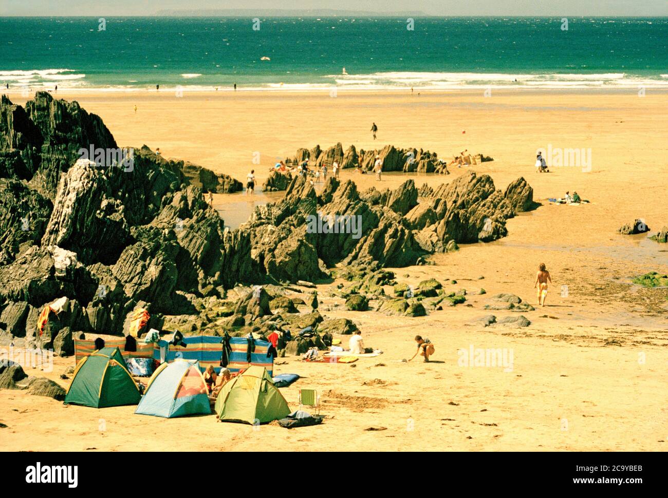 Holidaymakers and their windbreaks on Combesgate Beach,North Devon,U.K. Stock Photo