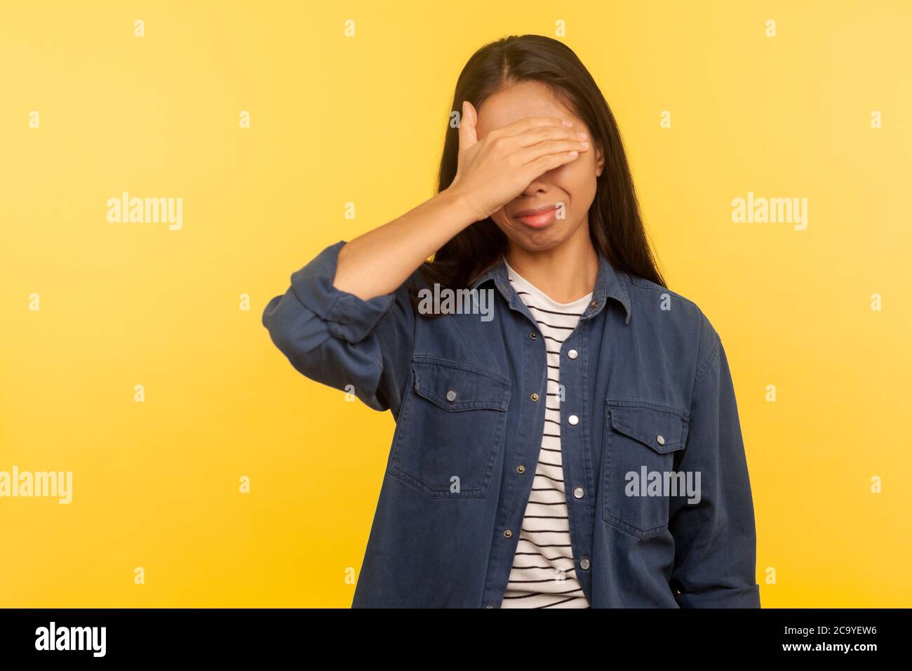 Don't want to look! Portrait of confused upset girl in denim shirt covering eyes, feeling afraid and disgusted to see something shameful, difficult to Stock Photo