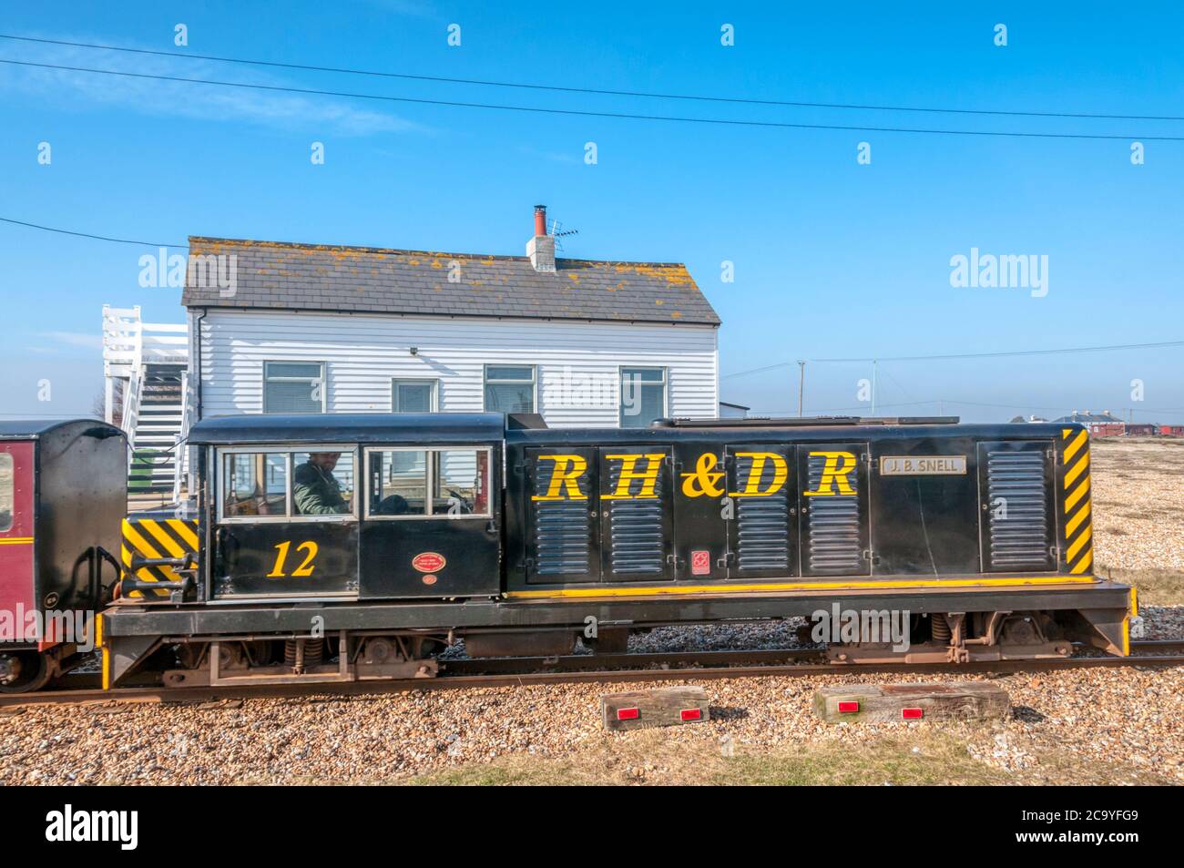 Diesel locomotive J. B. Snell of the Romney Hythe & Dymchurch Railway passes a cottage on Dungeness. Stock Photo