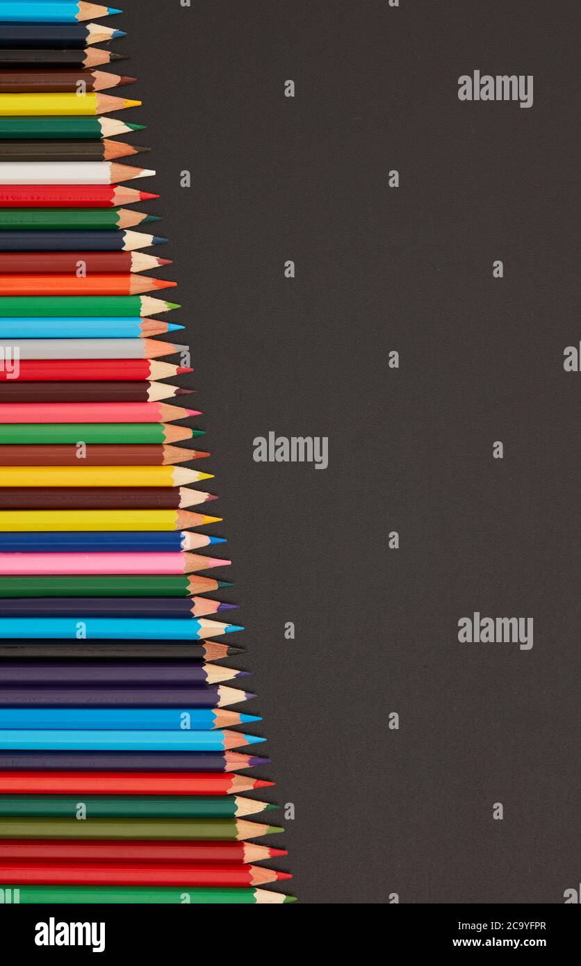 Multi-colored pencils on blackboard Stock Photo