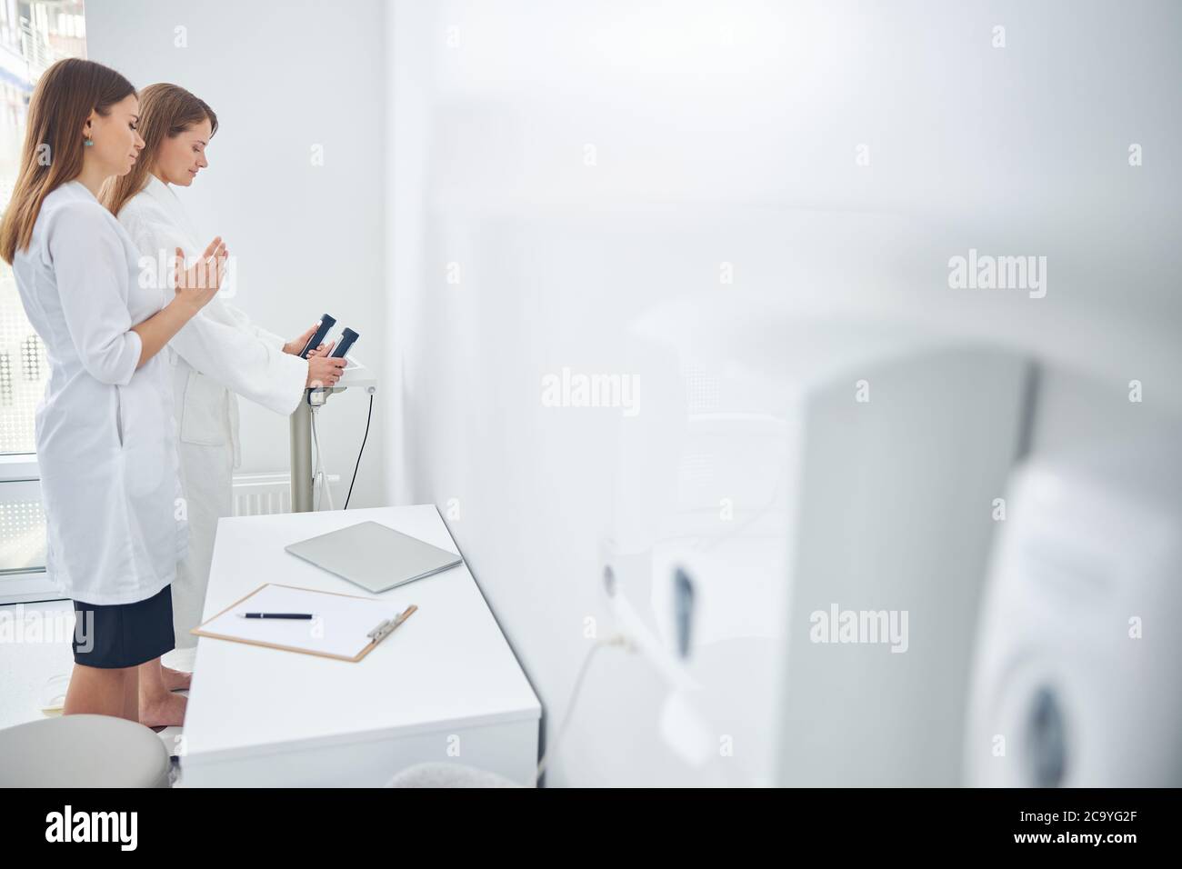 Two beautiful women measuring indicators of the health Stock Photo Alamy