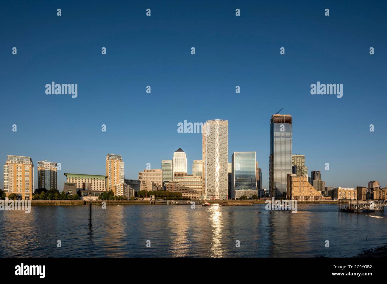 View across Thames from west with reflection in water. Isle of Dogs, London, United Kingdom. Architect: Various, 2020. Stock Photo