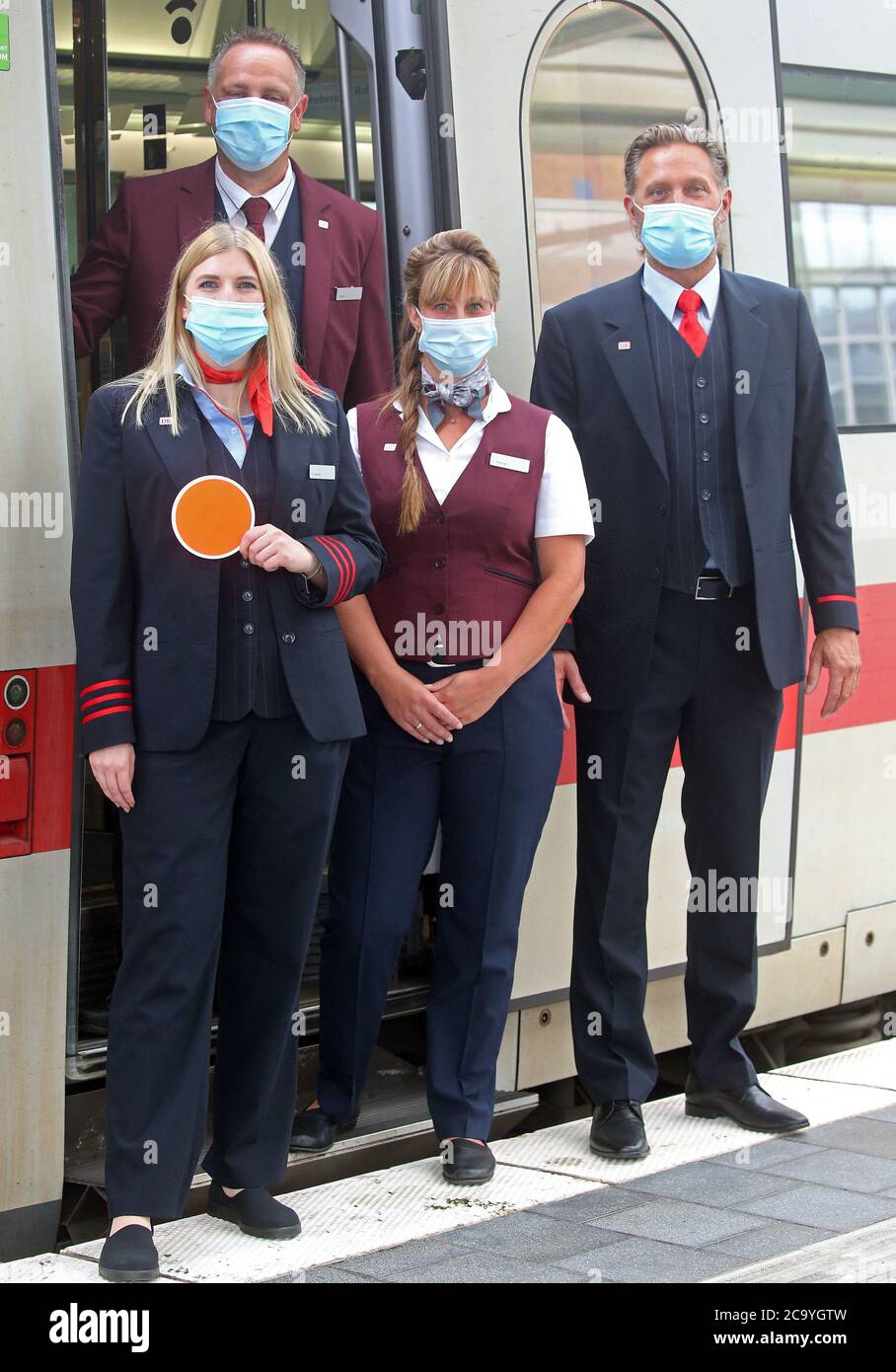 Berlin, Germany. 03rd Aug, 2020. With mouth and nose protection masks,  Deutsche Bahn employees take part in a presentation of the new corporate  clothing (M) of the railway at Ostbahnhof and show