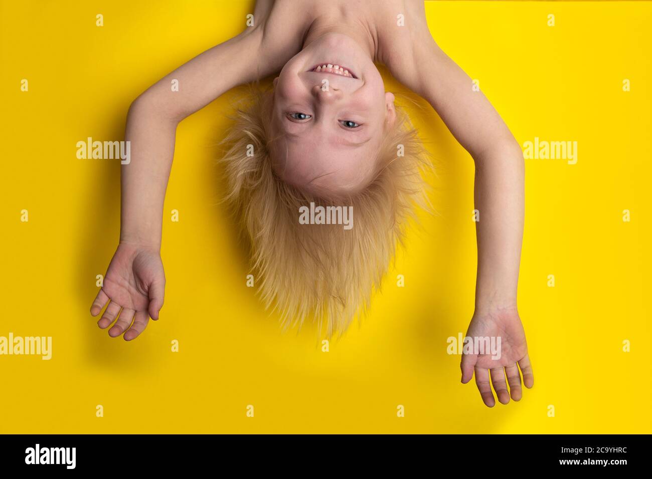Funny boy with blond hair hanging upside down on yellow background. Boy Mowgli Stock Photo - Alamy Funny boy with blond hair hanging upside down on yellow background. Boy Mowgli Stock Photo - Alamy