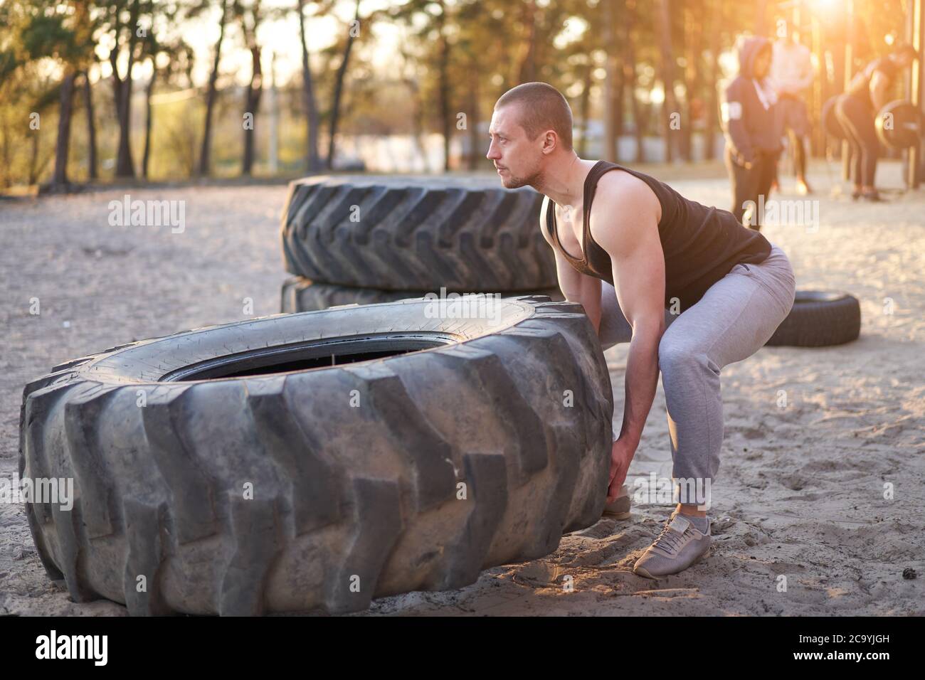 Strong man training workout lifting large tire outdoor DIY gym. Sportive  young adult caucasian guy flip big wheel on nature. Handmade equipment  sport Stock Photo - Alamy
