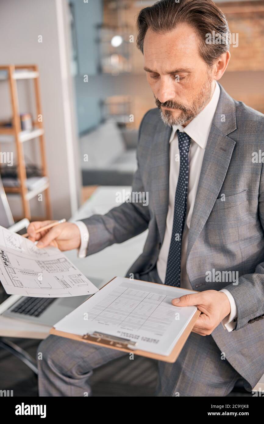 Handsome bearded man studying documents at work Stock Photo